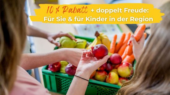 Kinder greifen in grüne Kiste mit Obst