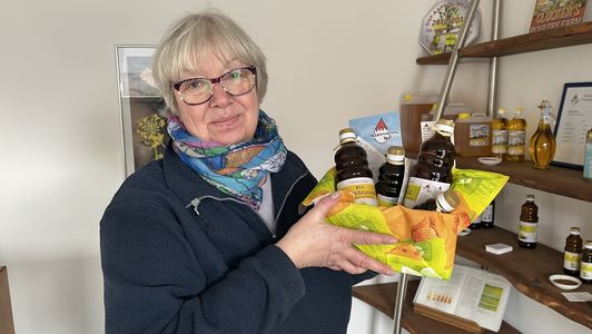 Martina Weinmann hält Geschenkkorb mit den Ölen vom Weinmannshof hoch