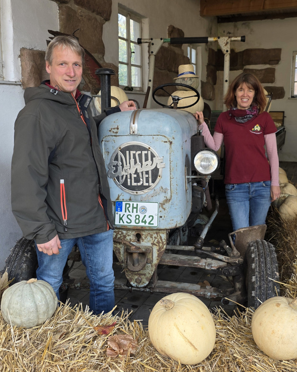 Martin und Petra Schnell vor altem Traktor