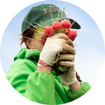 Frau hält sich Radieschen vors Gesicht