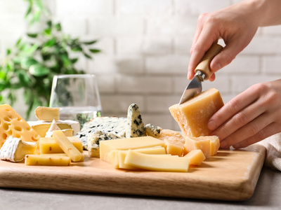 Person schneidet Käse