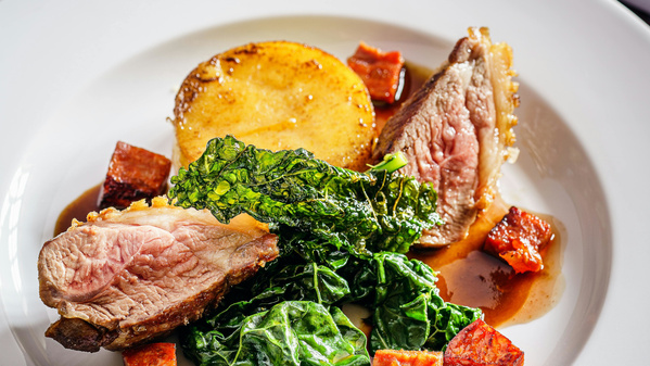 KI generiert: Ein Teller mit Fleisch, Wirsing, Polenta und Soße, angerichtet als feines Gericht.