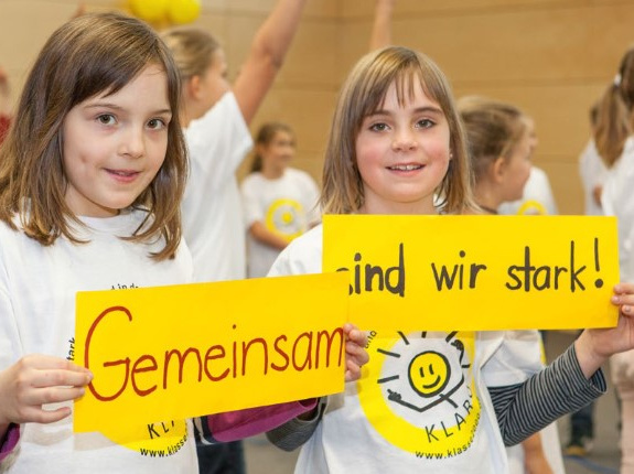 zwei Mädchen mit Schild 