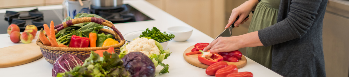 Person schneidet Paprika, Gemüse steht in der Küche