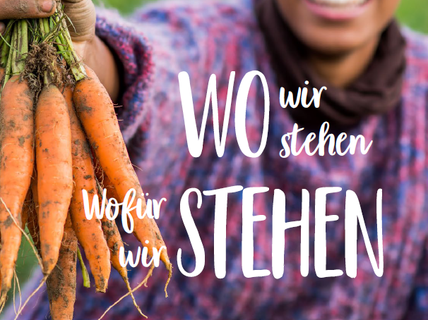 Frau hält Bund Karotten in der Hand - Schriftzug Wo wir stehen, wofür wir stehen