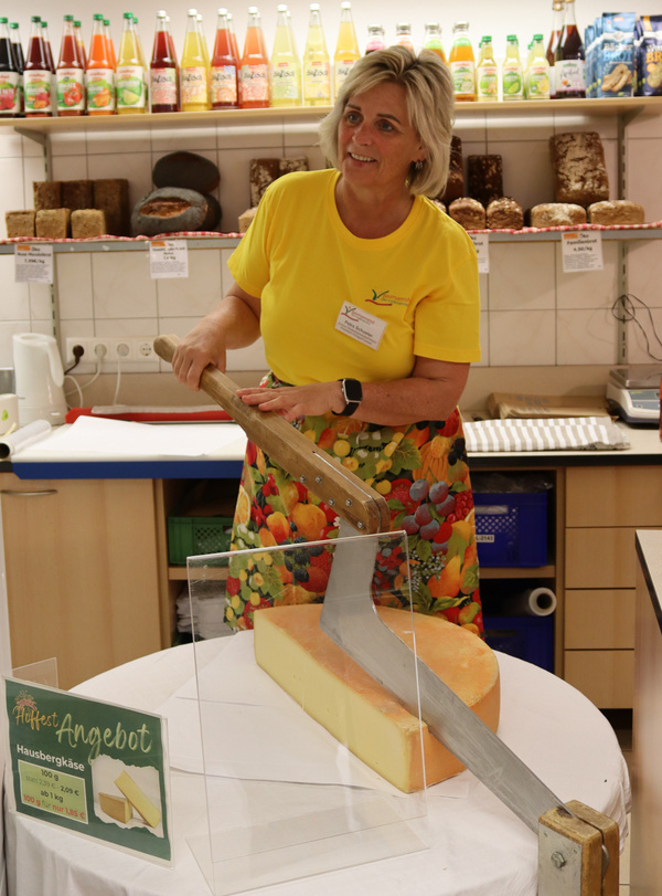 Mitarbeiterin des Baumannshofs beim Käseschneiden