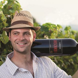 Mann mit Flasche Wein in den Weinbergen