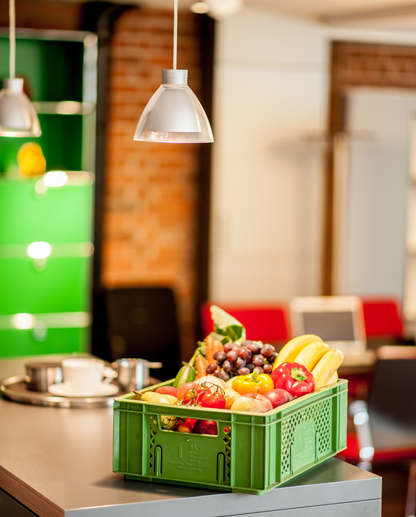 Kiste mit Obst und Gemüse steht in einer Küche