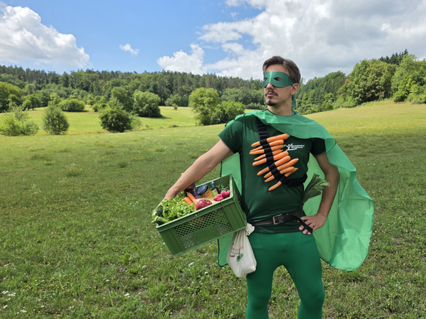 David als Heimatheld mit grünem Umhang und Gemüsekiste