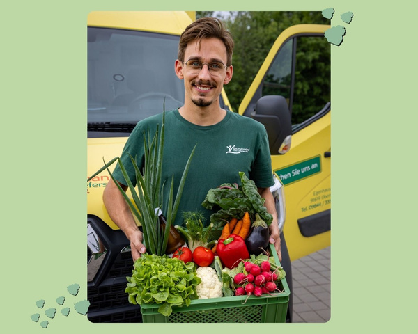David Baumann mit Gemüsekiste vor Lieferauto