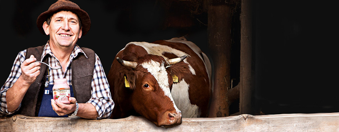 Person mit Joghurt neben einer Kuh