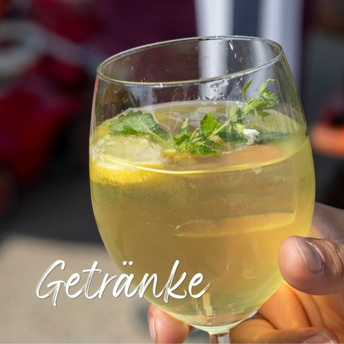 Person hält ein Glas Wein-Sprizz auf dem Hoffest Ökokiste Baumannshof