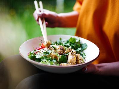 Person isst Bowl mit Stäbchen