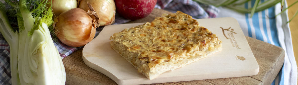 Stück Zwiebelkuchen auf einem Holzbrett